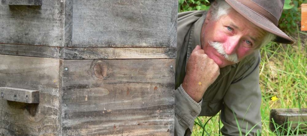 Bryan Divers, co-founder of Mamaki Farm and Village, poses with one of his Warre beehives.